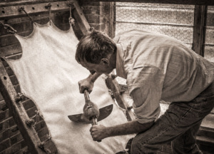 man making calfskin parchment paper